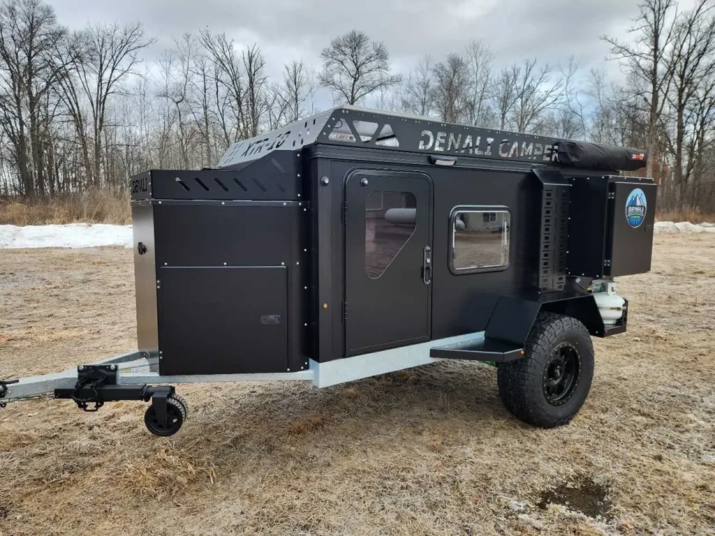 A compact black off-road camper trailer, labeled 